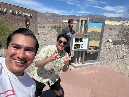Nathan Mendoza y su mejor amigo, ambos de Costa Mesa, California, con el reloj digital que marcó ayer los 55ºC.