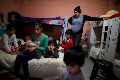 Natividad Benitez mira la TV junto a sus seis hijos, en su casa de la villa 1-11-14