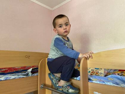 Nazar juega con su moto de plástico mientras su madre relata la destrucción en su ciudad