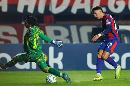 Nelson Ferreira, figura del partido, bloquea el remate de Rodrigo Auzmendi; el arquero de Recoleta FC, de Paraguay, fue infranqueable para los ataques de San Lorenzo