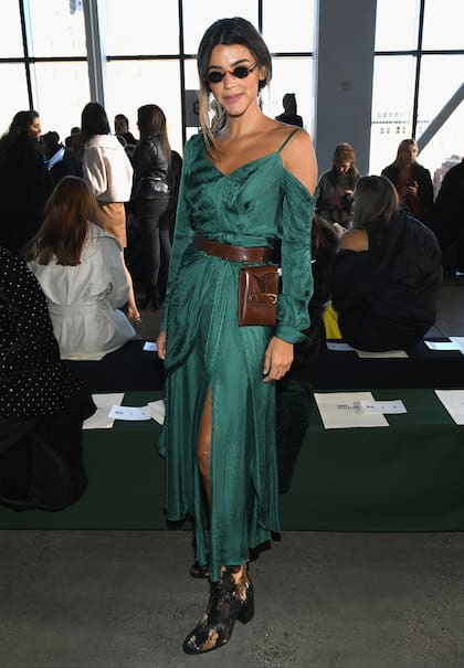 Durante el desfile de Self Portrait lució un vestido manga larga, con un hombro al descubierto, escote en V, cintura ceñida y tajo, creado por el dueño y director creativo de la firma Han Chong. Las gafas son de Giant Vintage, y las botas, de Dear Frances. El detalle de lujo es la riñonera de cuero
