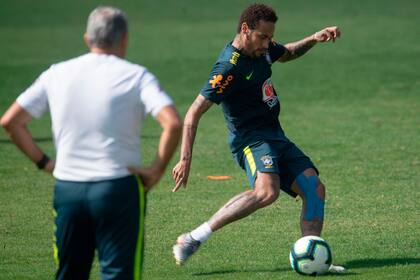 Neymar patea y Tite observa, en un entrenamiento de la selección brasileña.