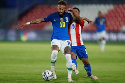 Neymar y Ángel Cardozo en pos del balón en Paraguay 0 vs. Brasil 2; el hábil atacante publicó el comunicado que aglutina la opinión del plantel que será local en la Copa América.