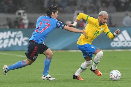 Neymar y Ao Tanaka luchan por la pelota durante el partido que disputaron Japón y Brasil.