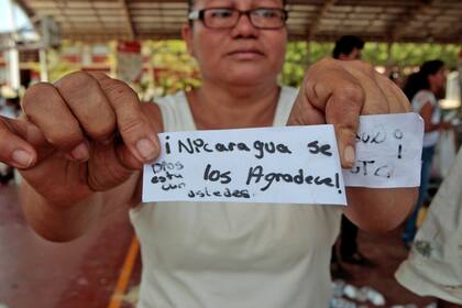 En medio de las protestas una mujer muestra un cartel que dice: "Nicaragua se los agradece, Dios está con ustedes"