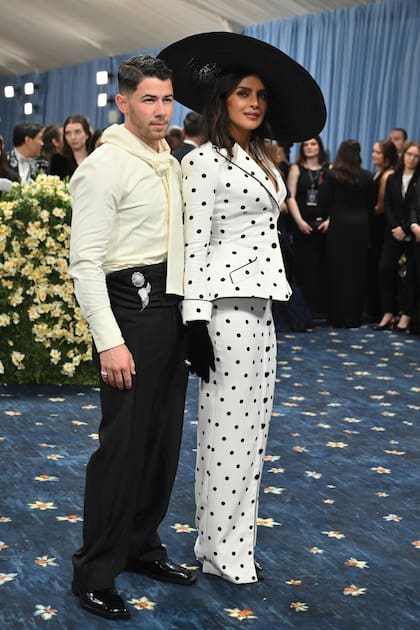 Nick Jonas y Priyanka Chopra fueron engamados. La actriz eligió un conjunto
de alta costura de Balmain, compuesto por una chaqueta estructurada en lunares negros y
hombreras marcadas y falda recta abotonada. Guantes y maxipamela, en negro. Nick optó por un
traje de toques modernos con pantalón con faja.