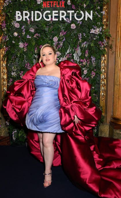 Nicola Coughlan fue la verdadera estrella de la velada. La actriz irlandesa combin en su outfit brillo, volumen y algo de osada con un diseo de la firma libanesa Sara Mrad. El vestido, en azul lavanda, corto y con escote palabra de honor, funcion como la base perfecta para una maxicapa roja satinada