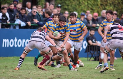 Nicolás Amaya, octavo de Hindú, afronta un tackle de Salvador Ochoa; van en respaldo Nicolás Leiva y, al fondo, Ezcurra.