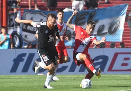 Nicolás Dematei se lleva la pelota ante la marca de Santiago González durante el partido por el segundo ascenso a la primera división disputado en Córdoba