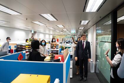 Nicolás entra a la oficina en uno de sus primeros días de trabajo. Sus colegas le dan la bienvenida con un cálido aplauso.