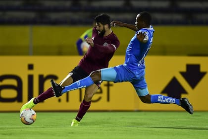 Nicolás Orsini remata ante Yuber Mosquera; durante 45 minutos, Lanús no la pasó nada bien en Ecuador.