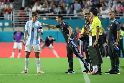 Nicolás Paz recibe instrucciones de Lionel Scaloni; el DT dejó al juvenil en la cancha los 90 minutos en Miami.