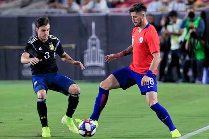 Nicolás Tagliafico intenta quitarle la pelota a Ángelo Sagal, durante el partido entre la Argentina y Chile.