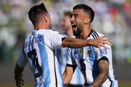 Nicolás Tagliafico saluda a Nicolás González, autor del último tanto argentino en la victoria frente a Bolivia por 3-0, en La Paz, por las Eliminatorias para el Mundial 2026