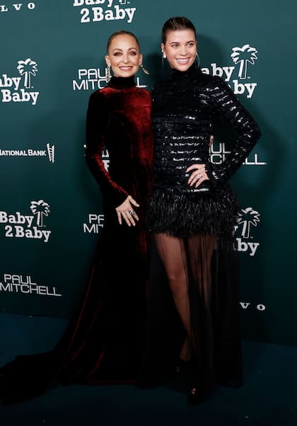 Nicole Richie siempre se destaca por sus looks. Esta vez eligió para la fiesta un vestido de manga larga y cuello alto color bordeaux. Sofía Richie, su hermana modelo, lució un estilo similar, pero en corto y con plumas en la falda