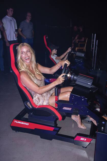 Nicole se divirtió probando los simuladores de autos de TC. A su lado se ve a Simoncito Icazuriaga, campeón 2024 de Karting de Centro.