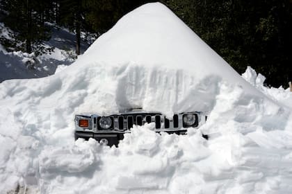 Un vehículo cubierto de nieve después de una serie de tormentas, en Lake Arrowhead, California