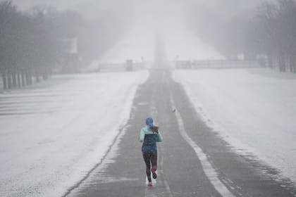 Una persona corre temprano en la mañana en la nieve en el Long Walk en el Castillo de Windsor, Berkshire, Reino Unido