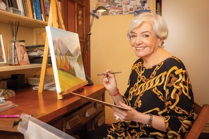 Nilda en su escritorio pintando. Aunque aprendió de grande, encontró en la pintura un refugio.