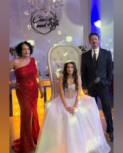 Nina, radiante, junto a su mamá y su papá, en uno de los momentos más emotivos de la noche