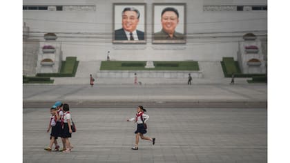 Niños pasean ante los retratos de los ex líderes Kim Il-Sung y Kim Jong-Il, en Pyongyang