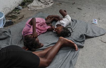 Niños duermen en el piso de una escuela donde los residentes del vecindario de Nazon que fueron desplazados por la violencia de pandillas han buscado refugio, en Puerto Príncipe, Haití, el jueves 14 de noviembre de 2024.