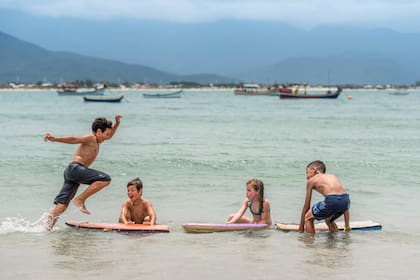 Niños jugando en la orilla del mar en la playa Pinheira.