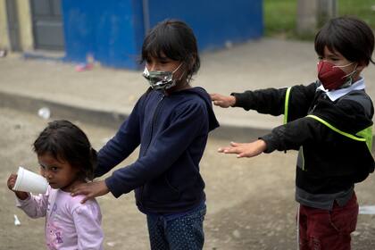 Niños migrantes hondureños que regresan a Honduras hacen fila para recibir comida de voluntarios de la Cruz Roja en El Florido, Chiquimula, Guatemala el 19 de enero de 2021