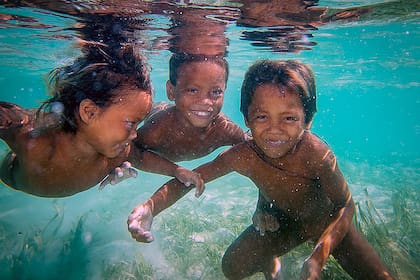 Niños moken jugando bajo el agua.
