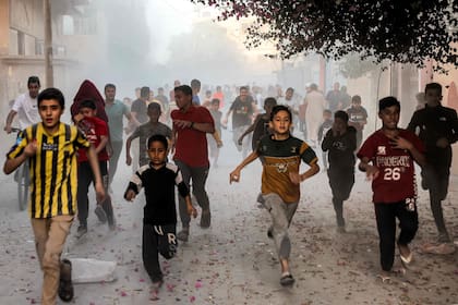 Niños palestinos corren mientras huyen del bombardeo israelí en Rafah, en el sur de la Franja de Gaza, el 6 de noviembre de 2023, en medio de continuas batallas entre Israel y el grupo militante palestino Hamas