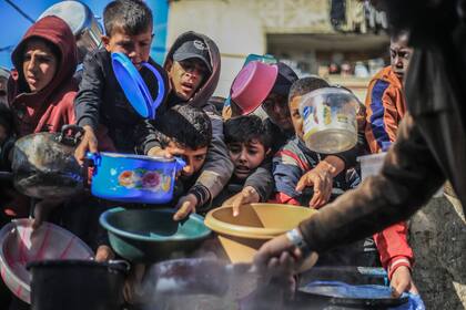 Niños palestinos reciben comida preparada en una cocina benéfica