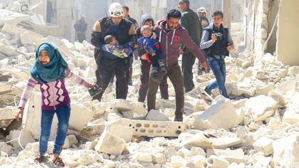 Niños sirios son rescatados tras un ataque contra la ciudad de Idlib, en poder de los rebeldes
