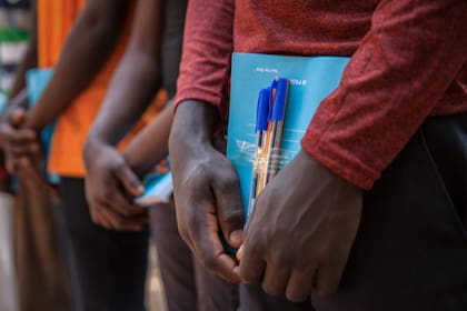 Niños soldados recién liberados reciben material escolar como parte de un kit de reintegración que incluye ropa y mosquiteros durante la ceremonia de liberación