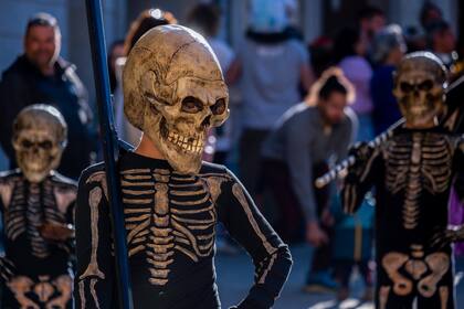 Niños y niñas vestidos de esqueletos se ven durante la procesión que representa la popular Danza de la Muerte que tiene lugar anualmente en Verges, Girona, España