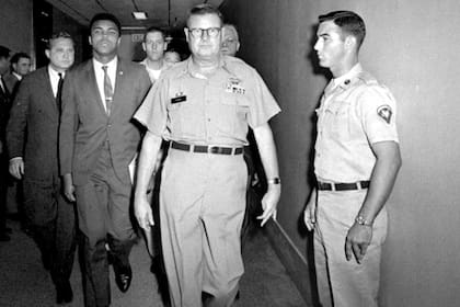 No a Vietnam: Muhammad Alí, acompañado por el comandante Edwin McKee en un centro de entrenamiento militar en Houston; el boxeador se negó a alistarse y fue sentenciado a cinco años de prisión; perdió todos sus títulos
