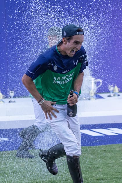 No iba a zafar: Poroto Cambiaso es empapado de champaña por uno de sus primos en el podio; el chico de 20 años obtuvo por segunda vez el Argentino Abierto.