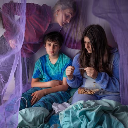 Lara, de 15 años, y Milo, de 13 años, en cama con fiebre del dengue en Buenos Aires, Argentina, con su madre Verónica
