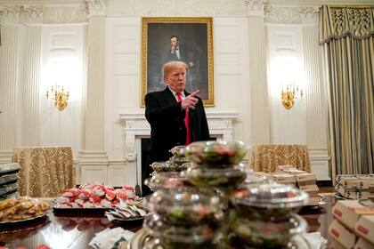 Trump con un banquete de comida rápida en paquetes de papel y de plástico