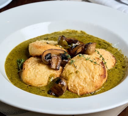 Ñoquis de sémola a la romana, preparados con sémola de grano duro, leche, manteca, parmesano y nuez moscada de Granero; se sirven con crema de espinaca y hongos frescos