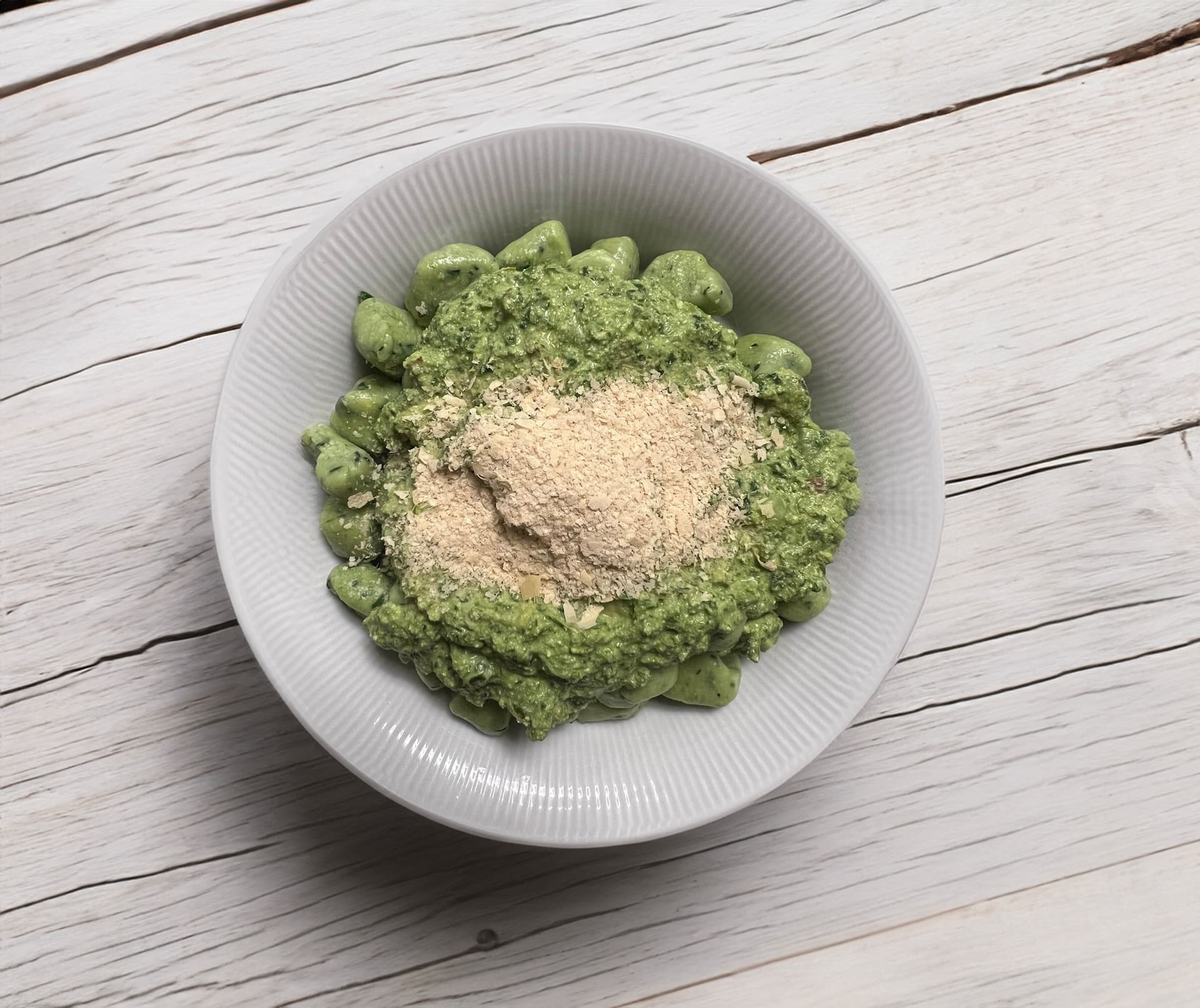 Ñoquis de tofu y kale con pesto de albahaca y levadura nutricional.