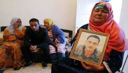 Nour Al Houda, madre de Anis Amri, el tunecino de 24 años cuyos documentos se hallaron en la cabina del camión que mató a doce personas en un mercadillo navideño de Berlín, posa con un retrato de su hijo