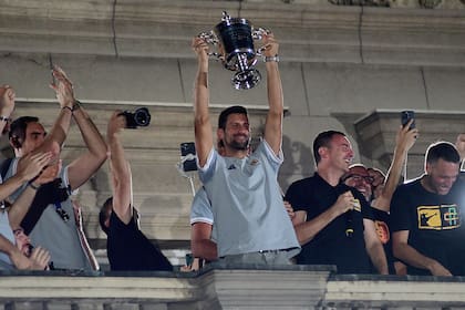 Novak Djokovic con el trofeo del US Open, junto al seleccionado de básquetbol subcampeón mundial, en Belgrado