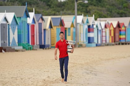 Novak DJOKOVIC sostiene la Norman Brookes Challenge Cup mientras celebra la victoria después de su final masculina individual en la sesión de fotos del trofeo en Brighton Beach el día después de ganar el Abierto de Australia, el lunes 22 de febrero de 2021.