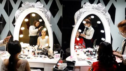 Novias se producen para la sesión fotográfíca en el estudio Golden Ladies en Beijing