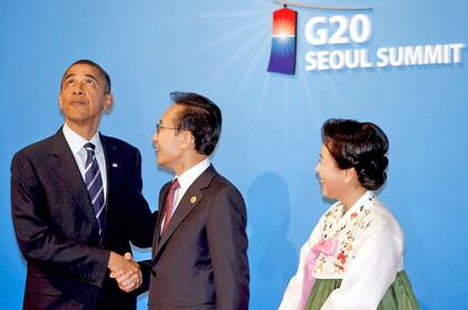 El expresidente surcoreano Lee Myung-Bak (centro) y su mujer Kim Yoon-ok saludan al expresidente estadounidense Barack Obama (izda) antes del comienzo de la cena de la cumbre del G20 celebrada en el Museo Nacional de Corea en Seúl