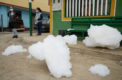 Nubes de espuma tóxica que se elevan desde el río Balsillas cubren partes de una calle y una vereda en el barrio Los Puentes en Mosquera, Colombia. (AP Photo/Fernando Vergara)