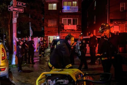 Oficiales de policía y rescatistas sacan a una persona que se había quedado atrapada en un sótano inundado en Queens, Nueva York (AFP)