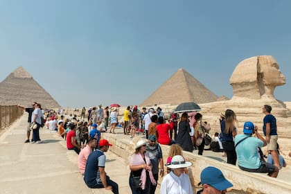 Numerosos turistas hacen fila y toman fotos en las inmediaciones de las pirámides y la Esfinge, en Egipto, en octubre de este año