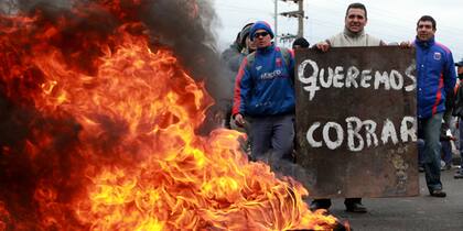 Obreros que trabajan en el proyecto de viviendas Suenos Compartidos para la Fundación Madres de Plaza de Mayo, durante un corte, ayer, en la ruta 197 a la altura del puente de Pacheco