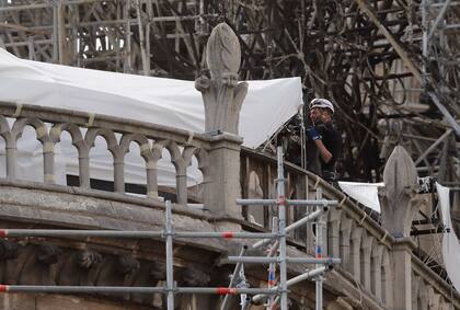Obreros trabajan colocando protecciones en las molduras de la catedral de Notre Dame